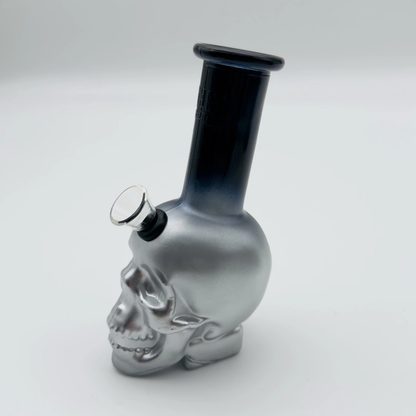 Silver skull-shaped glass pipe on a white background