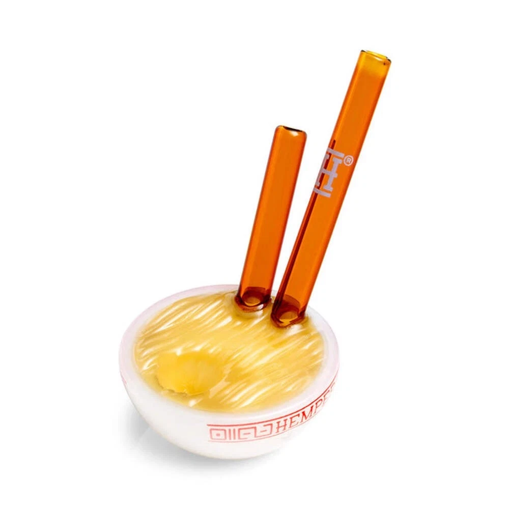 Two orange glass tubes with a white container holding a yellow substance on a white background